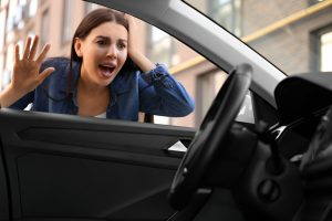 A panicked woman locked out of her car, illustrating the need for Knoxmith Lock & Key's emergency car lockout service in Knoxville, TN.