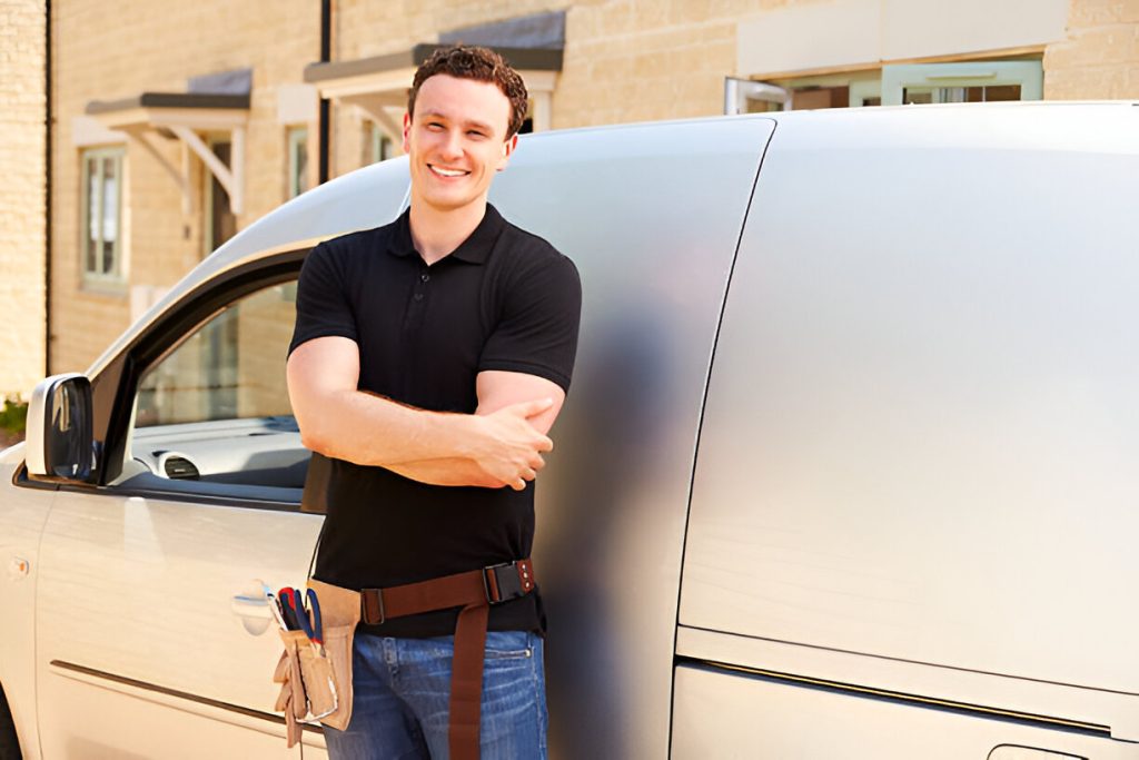 Portrait of a young tradesman by his van